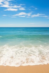 Obraz premium Gentle waves lap the sandy shore under a cerulean sky