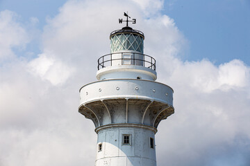 Lumière de phare au xénon avec une girouette sur un ciel bleu nuageux 