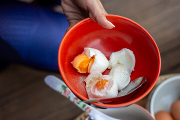Selective focus boiled chicken eggs sprinkled with pepper in an orange cup A delicious, simple, high-protein breakfast.
