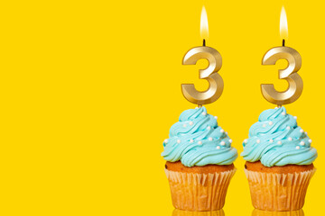 Birthday Cupcakes With Candles Lit Forming The Number 33.