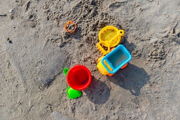 Top view of children's beach toys on sand on a sunny day