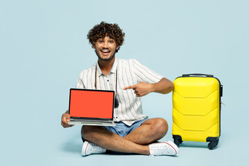 Traveler amazed IT Indian man wears white casual clothes sit hold blank screen laptop pc computer...