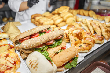 Fresh sandwiches, pies and pizza to choose from in the window of a cafe, buffet or self-service...