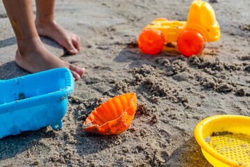 View of children's beach toys on sand on a sunny day