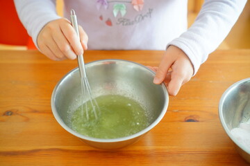 子供がグミを作っている様子。ホイッパーでまぜまぜ。