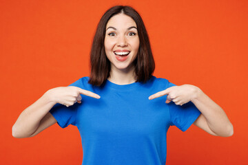 Young smiling happy cheerful fun woman she wearing blue t-shirt casual clothes point index finger...