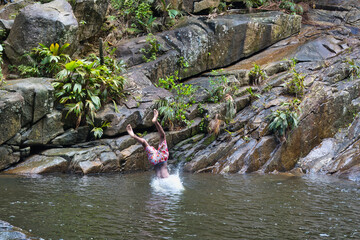 Mahe, Seychelles 6.05.2024 Young boys having fun diving from granite rock into the water at the...