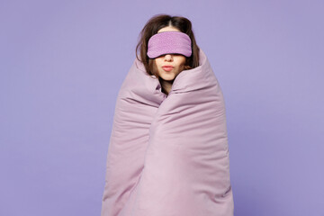 Young happy calm woman wear pyjamas jam cover eyes with sleep mask, wrapped in duvet rest relax at...