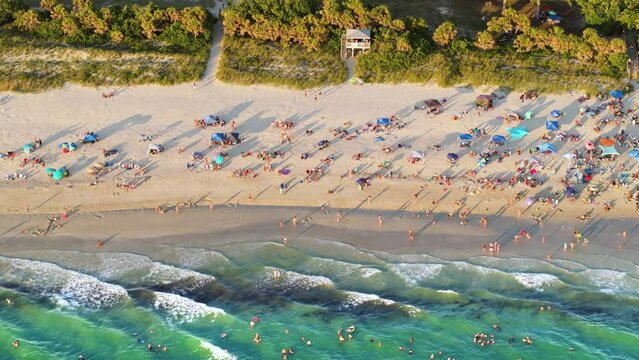Nokomis sandy beach in Sarasota County, USA. Many tourists enjoying summer vacation time swimming in warm Mexico gulf water and sunbathing on hot Florida sun