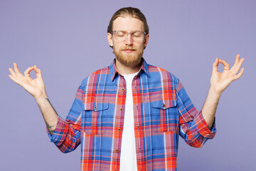 Young spiritual happy man wear blue shirt casual clothes hold spread hands in yoga om aum gesture relax meditate try to calm down isolated on plain pastel light purple background. Lifestyle concept