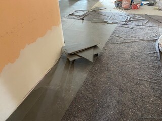 Verschmutzte fliesen w&auml;hrend der bauarbeiten in basalt mit einer t&uuml;te und abdeck vlies