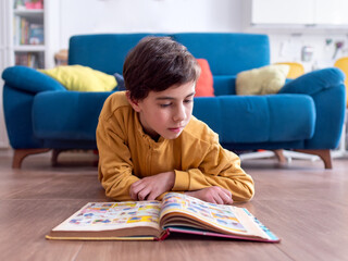 Young Child Engrossed in Reading a Colorful Book on Floor