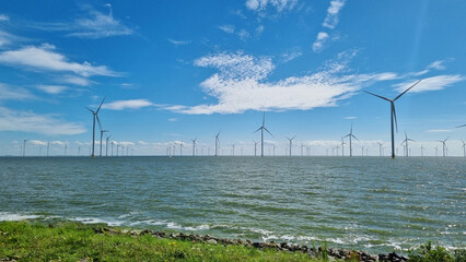 Windmills along a large body of water