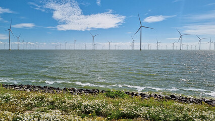 Windmills along a vast body of water