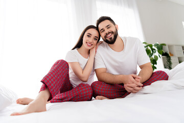 Photo of pretty attractive couple wear white t-shirts embracing indoors apartment bedroom