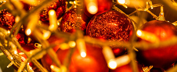 Banner close up of red Christmas balls baubles. Bokeh garlands. Xmas and holidays concept. Copy...