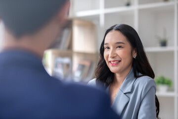 A young businessman and a female Asian accountant are discussing financial accounting and business...