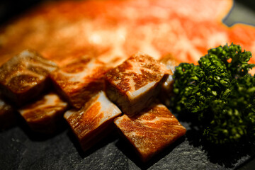 meticulously cut and well-arranged beef with premium marbling alongside fresh green herbs