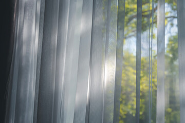 Transparent white curtain with window view with tree garden background.