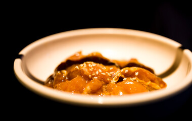 a bowl where freshly marinated chicken pieces are being served