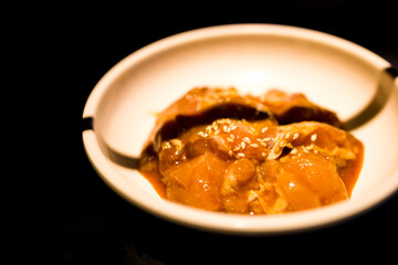 a bowl where freshly marinated chicken pieces are being served