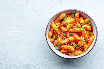 Tteokbokki or topokki, Korean street food, spicy rice cakes in red pepper gochujang sauce, shot from above with a place for text