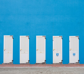 Changing cabins on the beach of a bathhouse with signs on it. Italy, Cesenatico. Empty space on top