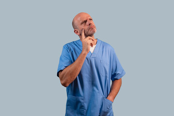 Portrait of a physiotherapist wearing a light blue coat and in a thoughtful attitude.