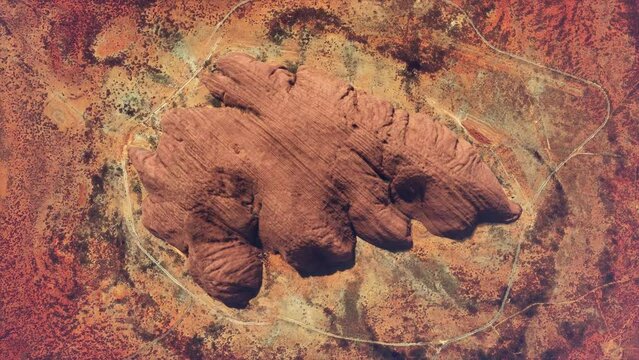 Aerial top down view of Uluru also known as Ayers Rock is a large sandstone monolith near the centre of Australia listed as a UNESCO World Heritage Site and popular tourist destination 4k animation