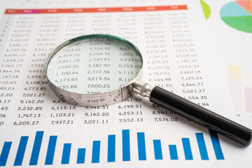 Magnifying glass on spreadsheet and graph paper. Financial development, Banking Account, Statistic,...