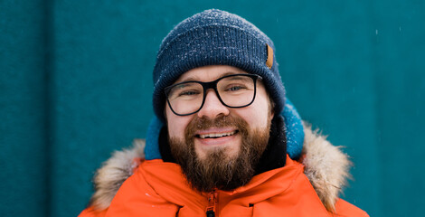 Banner portrait handsome eyeglasses young male smiling bearded stands on a blue wall background in...