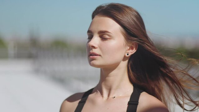 Close portrait of a woman, model, with closed eyes, hair flying, skin, care, beauty, glamour, cover, magazine, health and youth, confidence, femininity, roof, lifestyle, meditation, breathing, peace