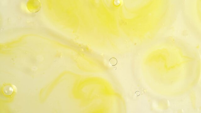 Macro shot of drops of orange essential oil  in water, rotate, top view.  Cosmetics background, close up.