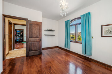 a room with wood floors and white walls with a blue drapes is shown