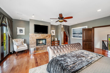 a well - appointed bedroom with large windows and hardwood flooring