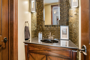 the bathroom is decorated in a black and white theme and features dark granite