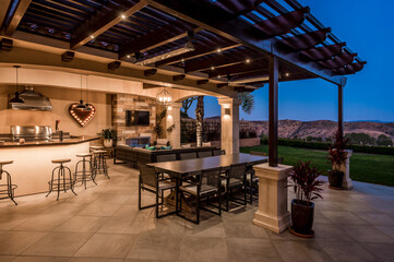 an outdoor bar and dining area is set in front of the kitchen