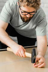 Portrait of man assembling furniture. Do it yourself furniture assembly at home