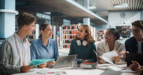 Diverse Group of Students Collaborating on a Project in a Modern Library. Young Adults Engaged in Discussion, Using Laptop and Documents, Smiling and Sharing Ideas in an Educational Setting