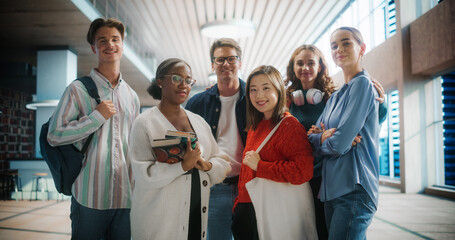 Diverse Group of Students Posing in Modern University Hallway. Young Men and Women of Various Ethnicities Smiling, Holding Books and Backpacks, Ready for Academic Challenges.