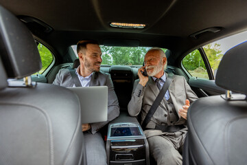 Senior executive discussing business strategies with colleague during morning commute