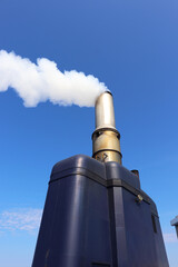 white smoke from a chimney against a blue sky