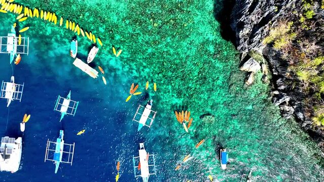 Aerial Top View of Bangka Boats as sand beach by a crystal clear water. Entalula island, Bacuit Bay, El Nido, Palawan, Philippines.