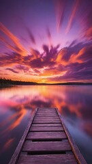 a wooden dock stretches into a lake at sunset with bright light shining on it
