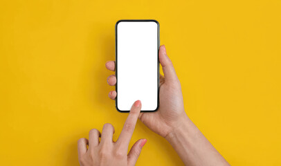 Mockup phone. Hand holding black smartphone with blank screen and modern frame less design on yellow background. mockup for presentation template.