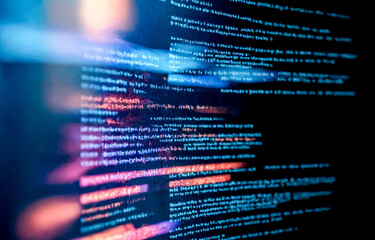 closeup view of computer screen showing lines of digital code. Blurred image essence of data processing, with visible lines of code. illustrating coding, encryption