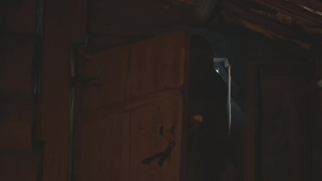 Elders in vintage robes coming inside wooden izba. Media. Men open the wooden beam door and coming inside old house.