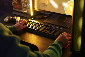 Man playing video games on computer indoors, closeup © New Africa