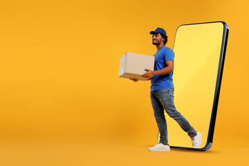 Courier with parcel walking out from huge smartphone on orange background. Delivery service. Space...