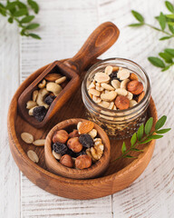Variety of nuts and dried fruits in wooden bowls, ideal for healthy snacking.